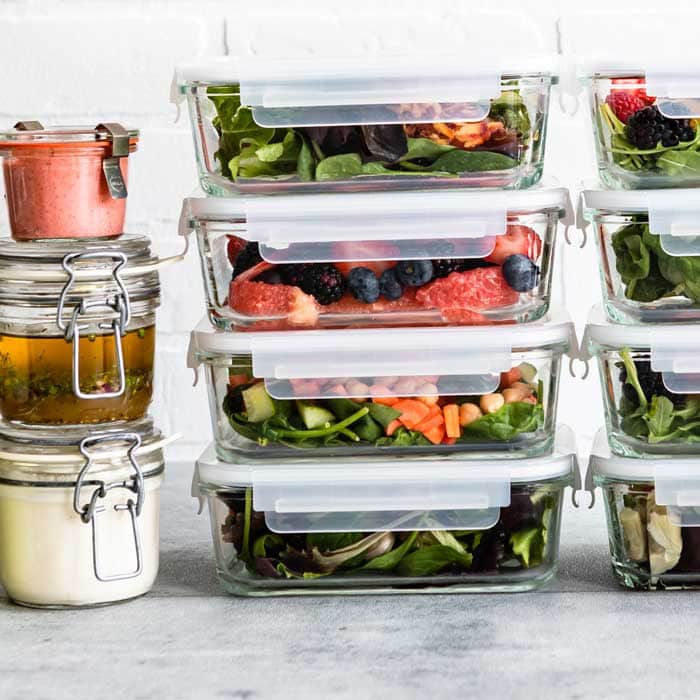 Glass containers filled with prepped whole grains, vegetables, and legumes ready for the week